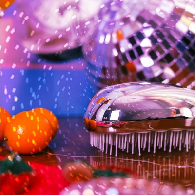 Brosse démêlante compacte AGAMY argent brillant en ambiance festive avec déco de Noël et paillettes